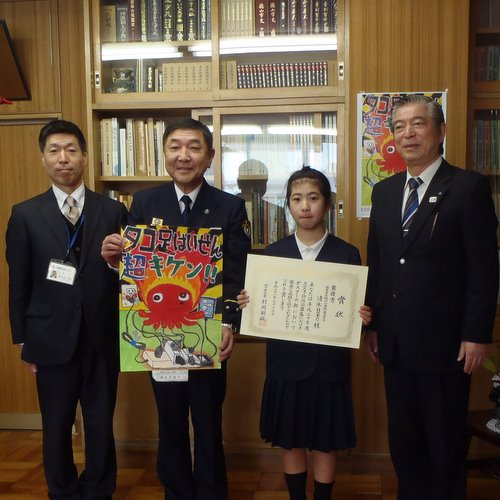 受賞の賞状を持った清水日菜乃さんと、3人の男性が写っている写真です