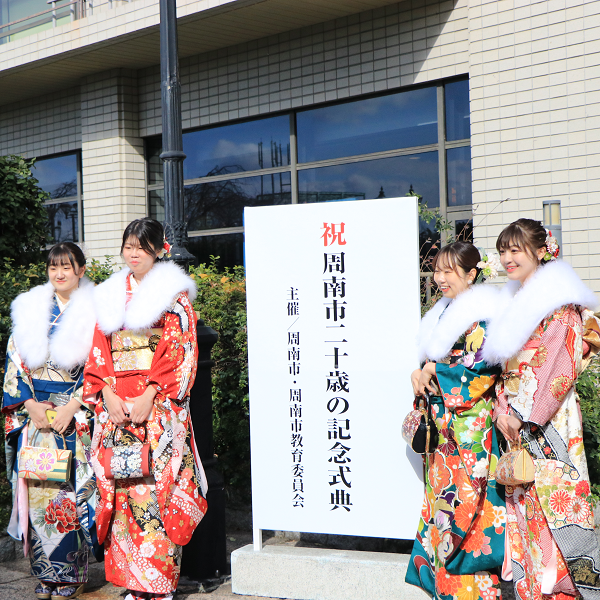 看板前で記念写真を撮る振袖の女性たち