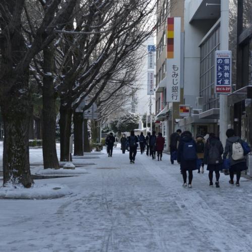 市内、雪の積もった御幸通りと、行きかう人々が写っています。