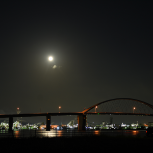 夜の空に輝く月と周南大橋と工場夜景